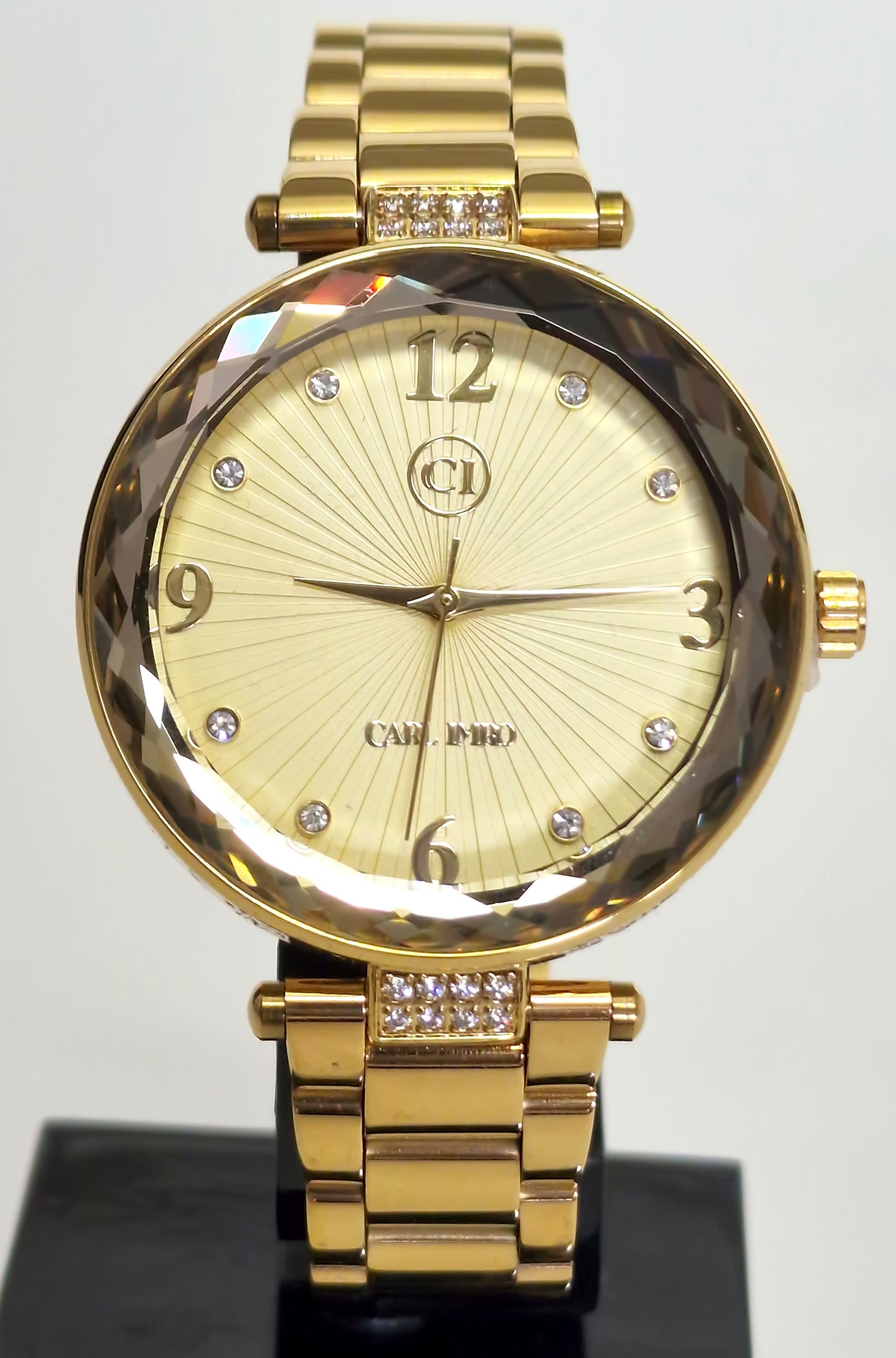 Montre femme plaquée or, cadran ivoire rayonné, chiffres arabes, strass sur le maillon central
