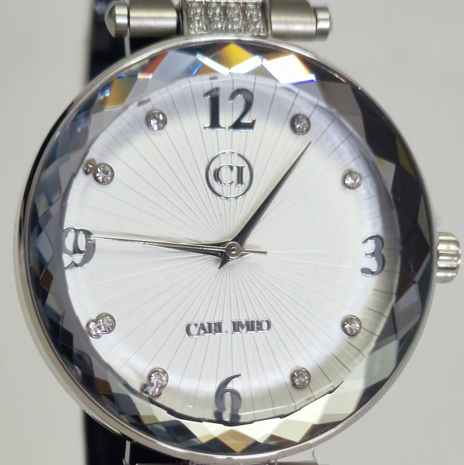 Montre homme cadran argenté avec logo CI, index pierres, aiguilles et bracelet acier.