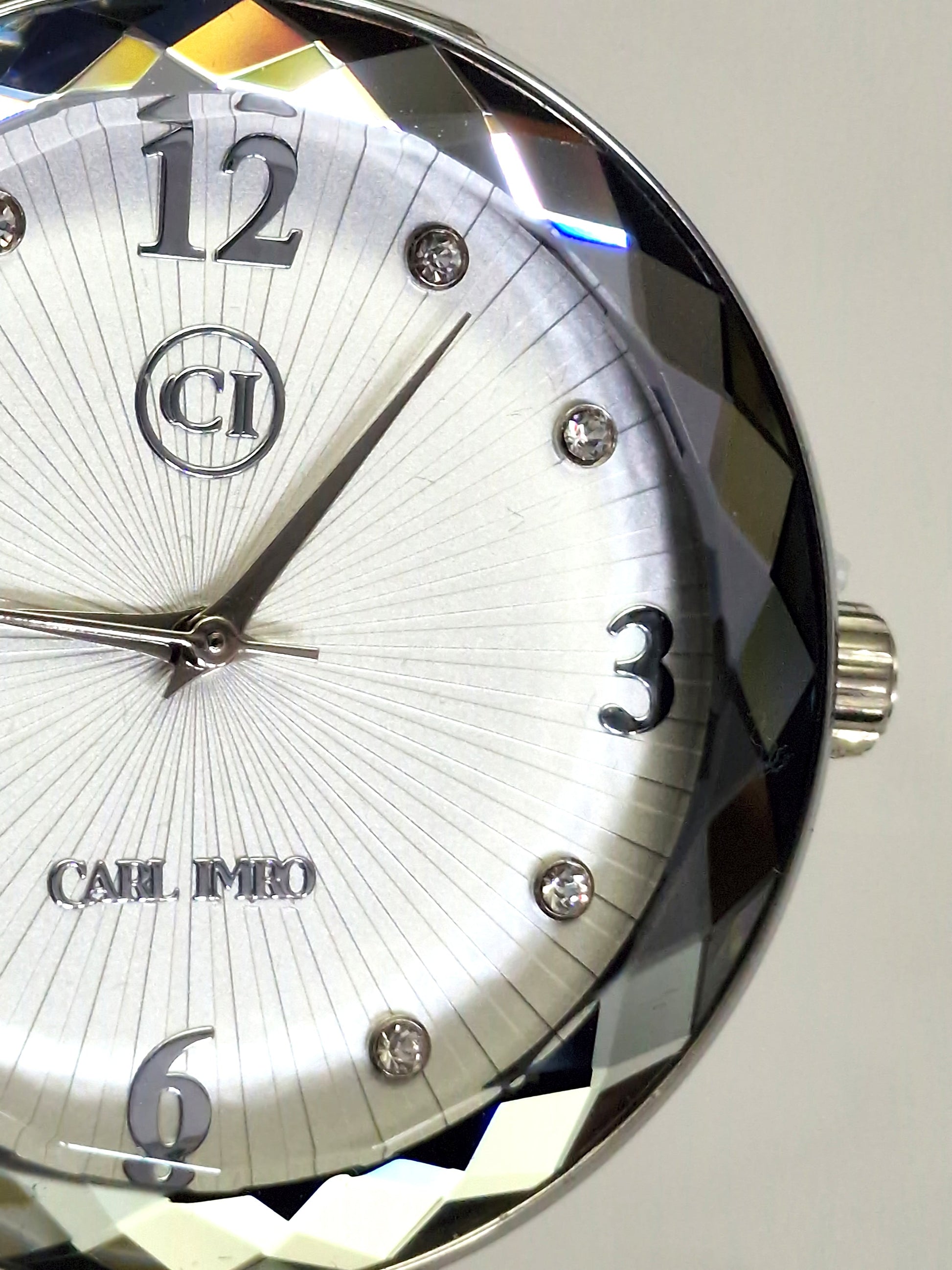 Montre homme cadran argenté, chiffres 12,3,6 et couronne sur la lunette