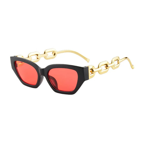 Lunettes de soleil œil-de-chat à monture noire, verres miroirs rouge et temples chaîne dorée.