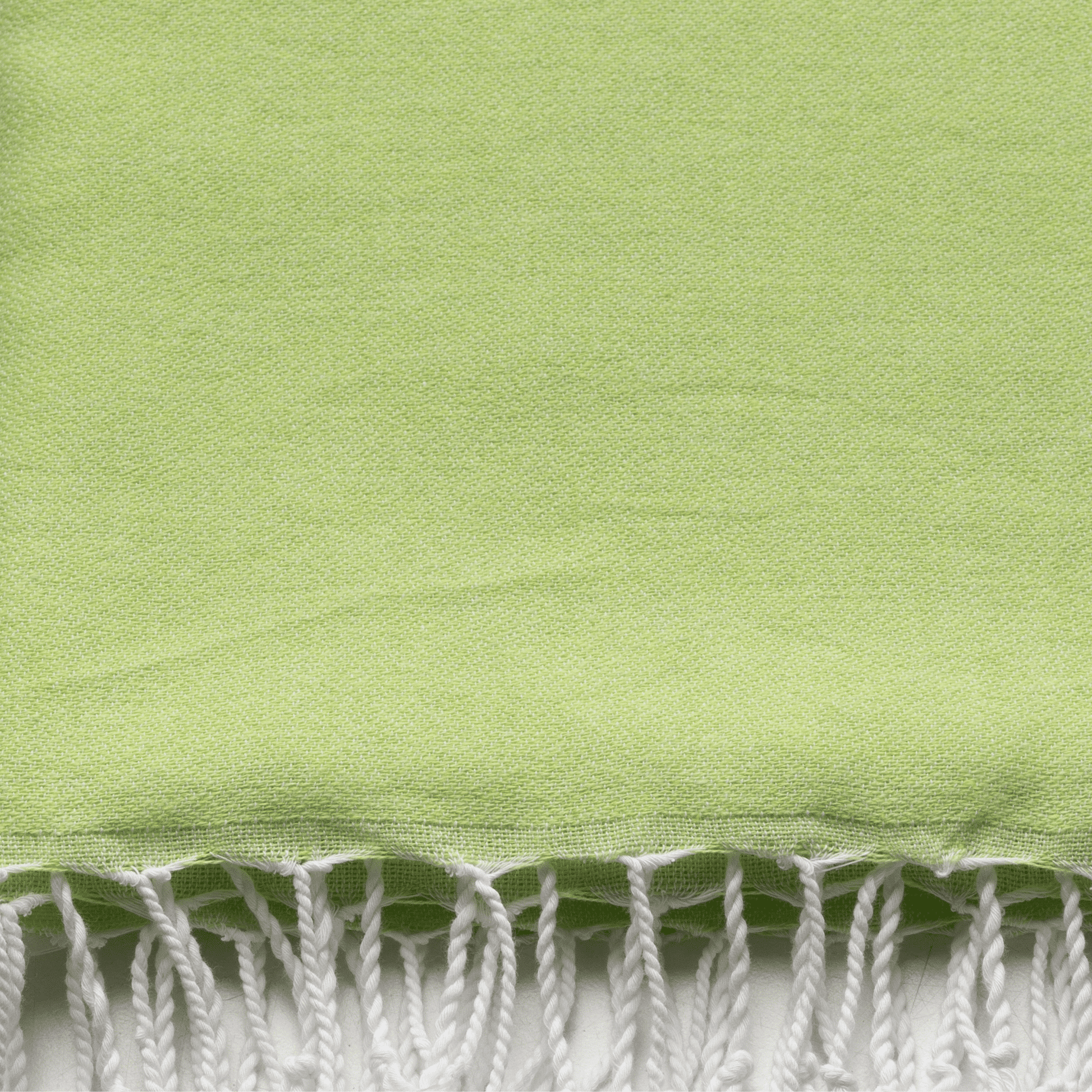 Bord frangé blanc sur tissu de serviette vert