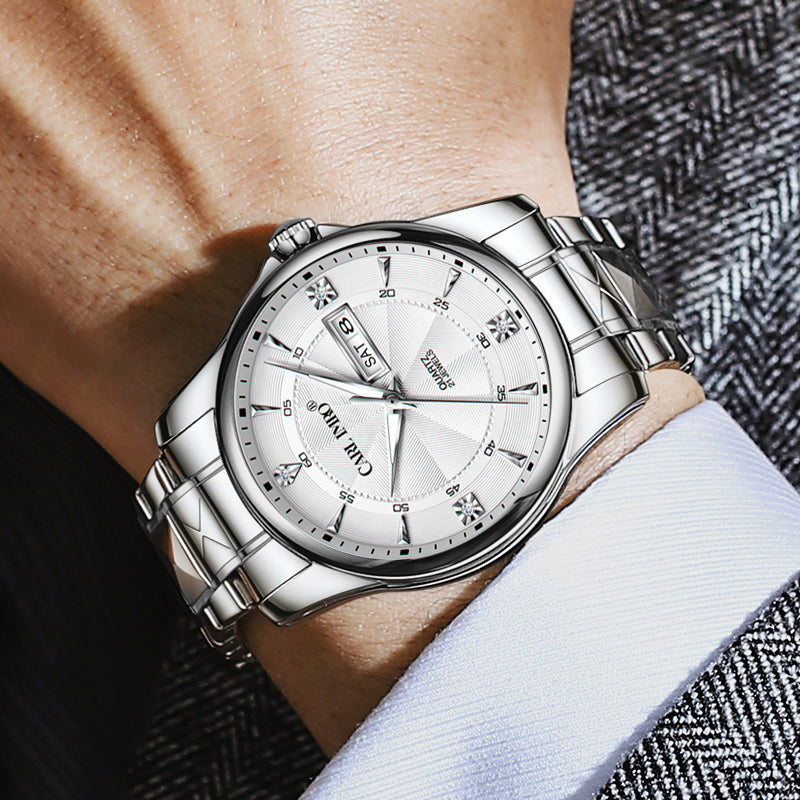 Montre-bracelet cadran argenté en gros plan, bracelet acier et fenêtre de date.