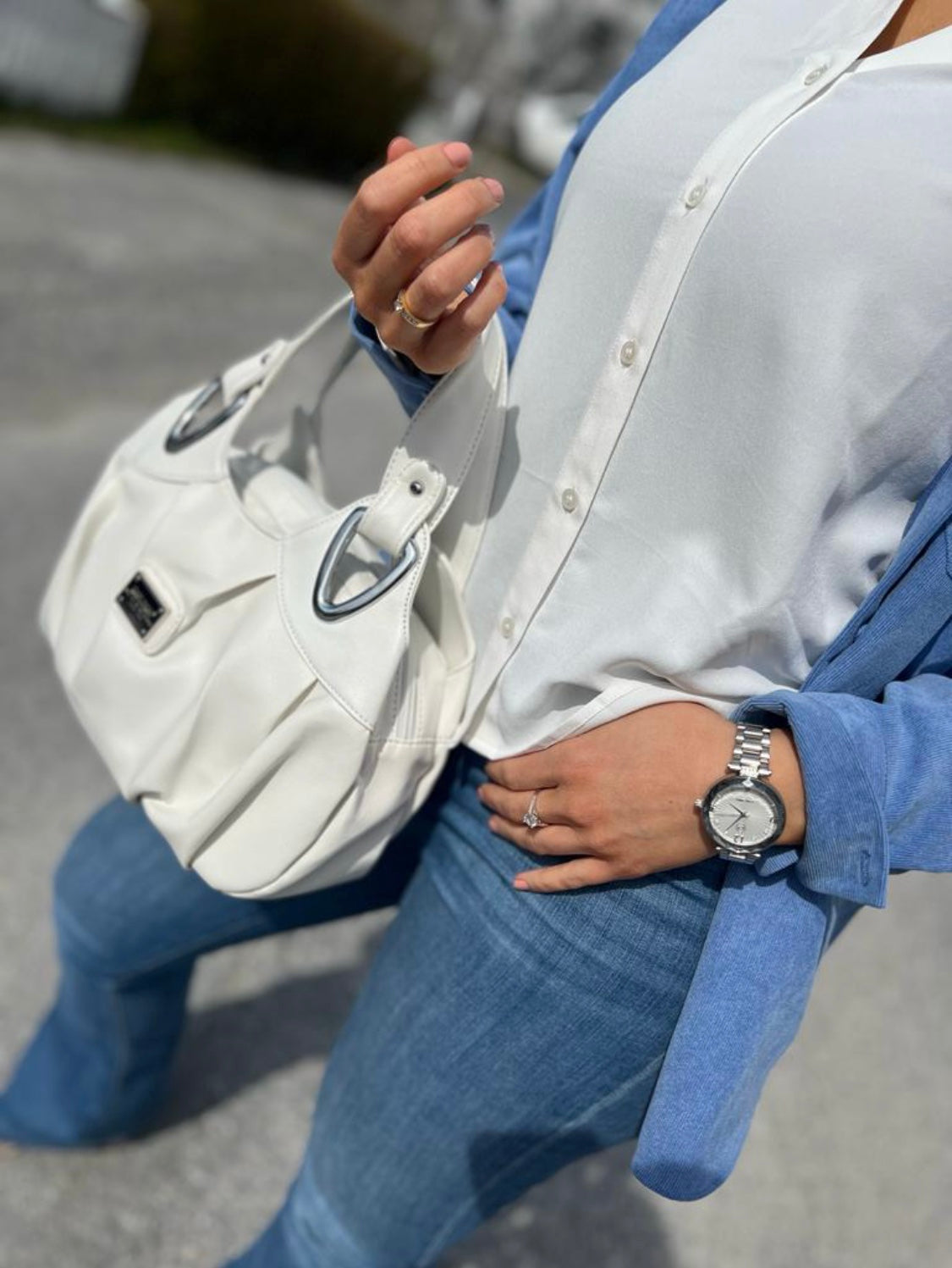 Montre homme au poignet, cadran clair et bracelet acier à maillons.