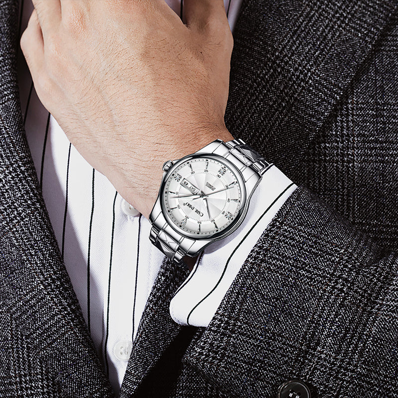 Montre-bracelet homme en acier sur poignet, cadran argenté et bracelet à maillons.