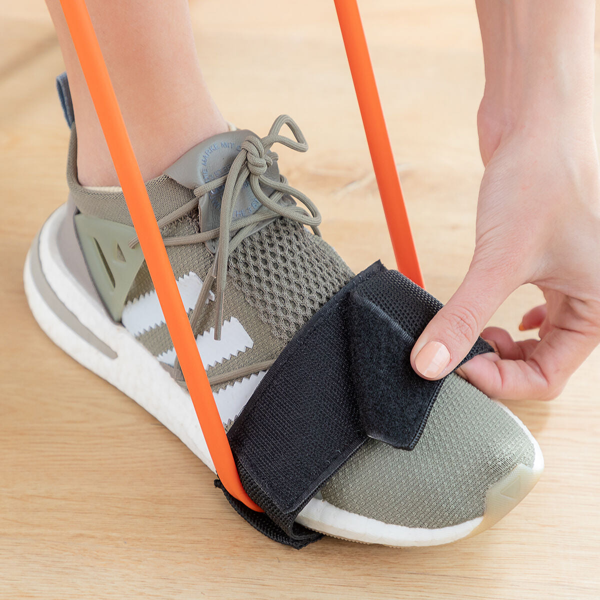 Ceinture de renforcement fessiers avec sangle noire sur chaussure, attaches élastiques