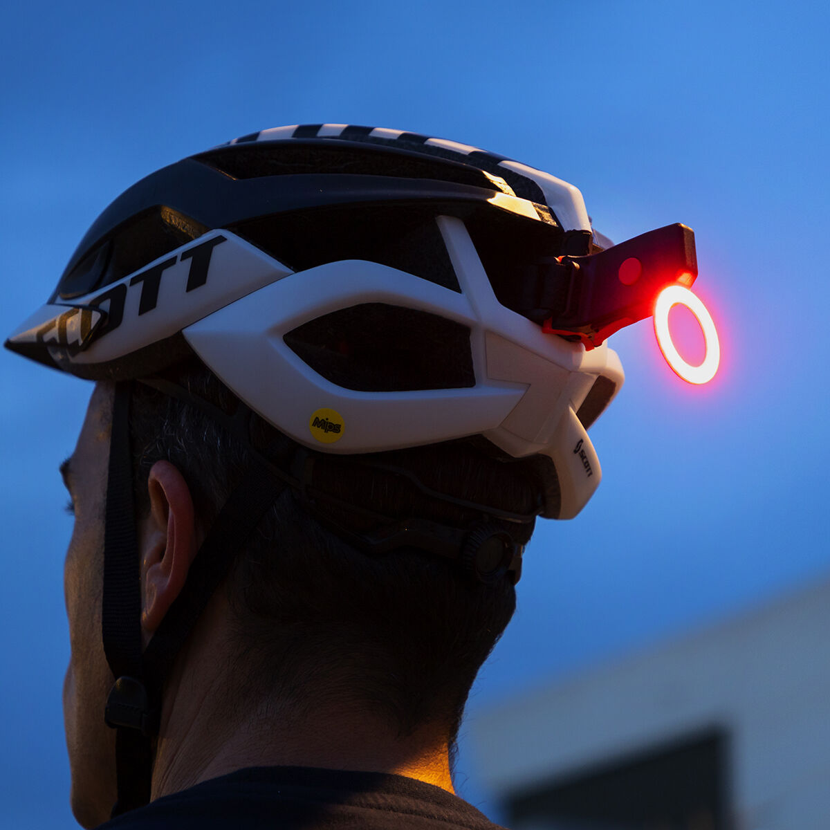 Feu arrière LED rouge clignotant sur vélo, lumière rouge visible de côté.