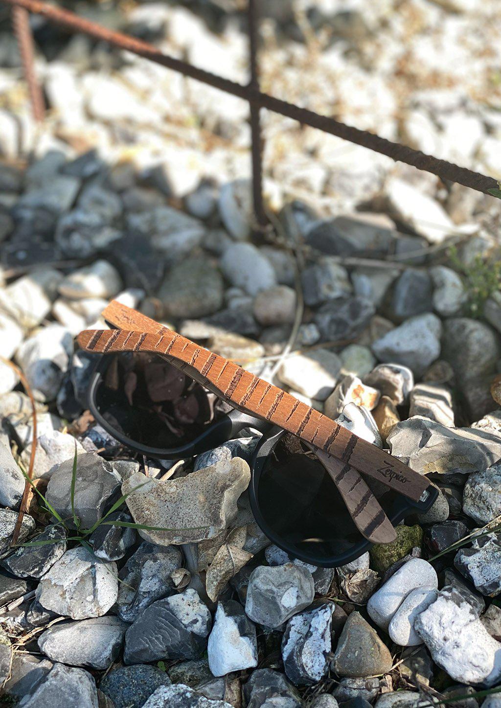 Lunettes de soleil Eyewood en bois de noyer gravé, verres foncés, branches courbées.