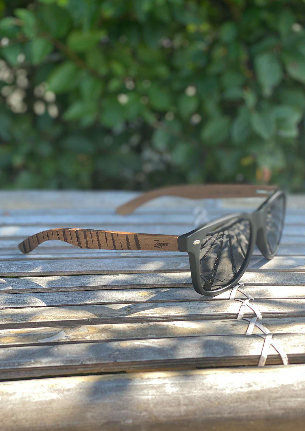 Lunettes de soleil Eyewood en bois de noyer gravé, verres fumés foncés, profil.