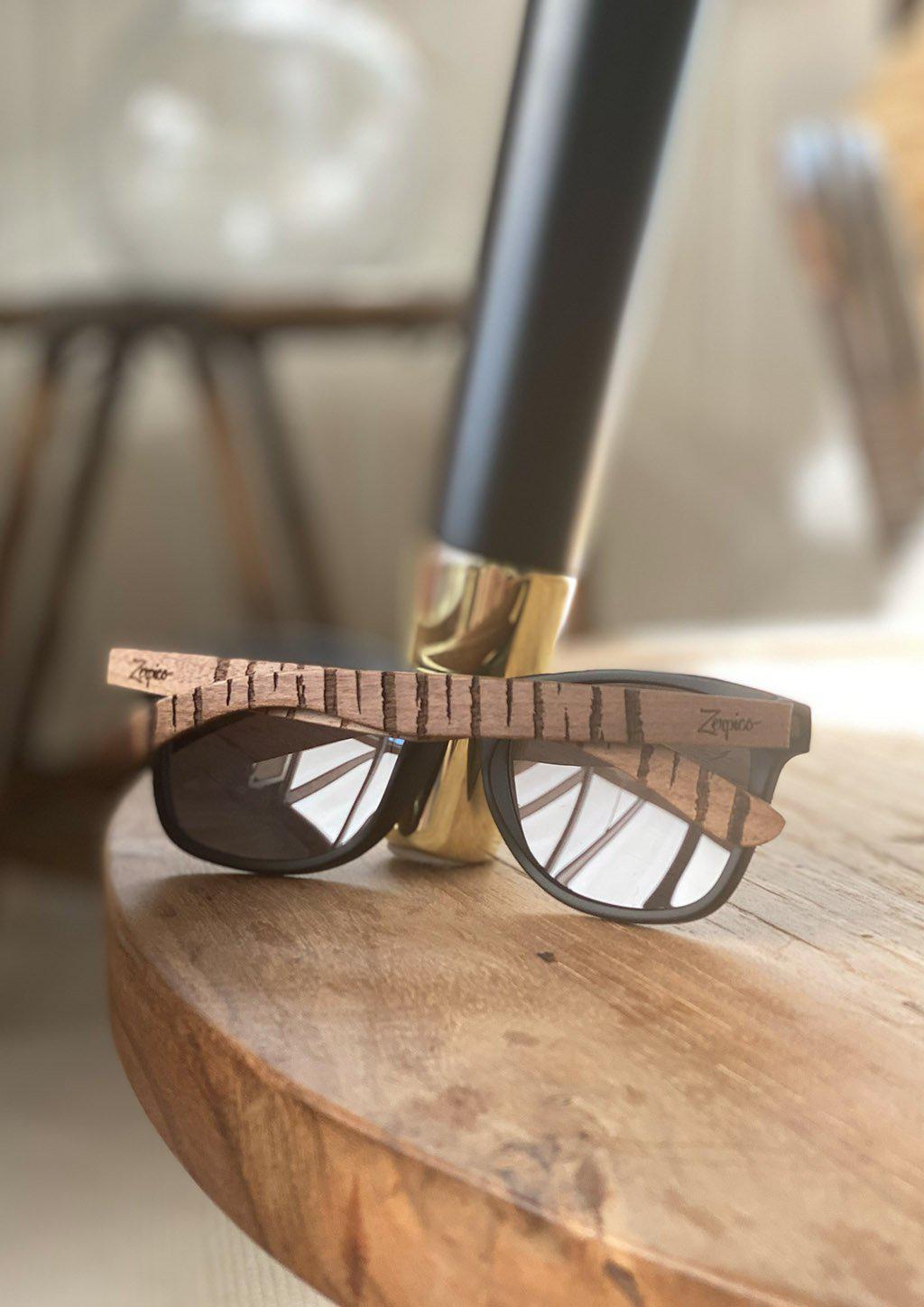 Lunettes de soleil Eyewood en bois gravé noyer, verres foncés, vue rapprochée.