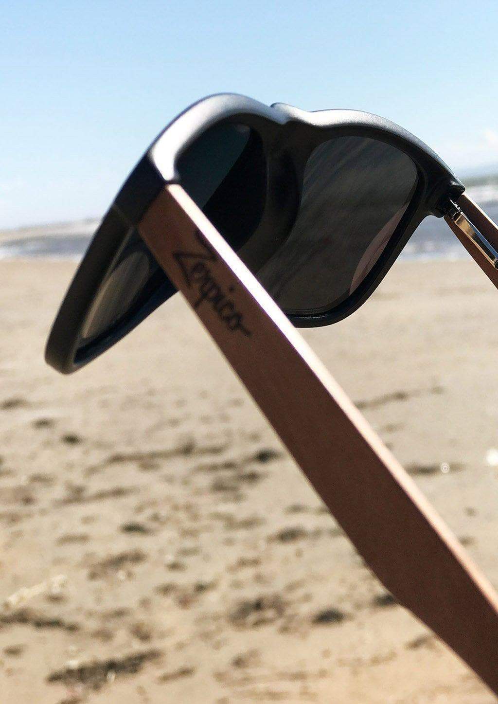 Lunettes de soleil noires avec verres foncés et branche en bois brun, vue de côté