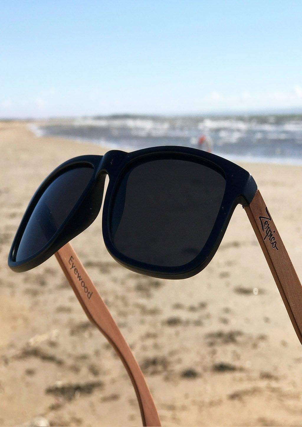 Lunettes de soleil noires avec branches en bois brun et verres foncés, vue rapprochée