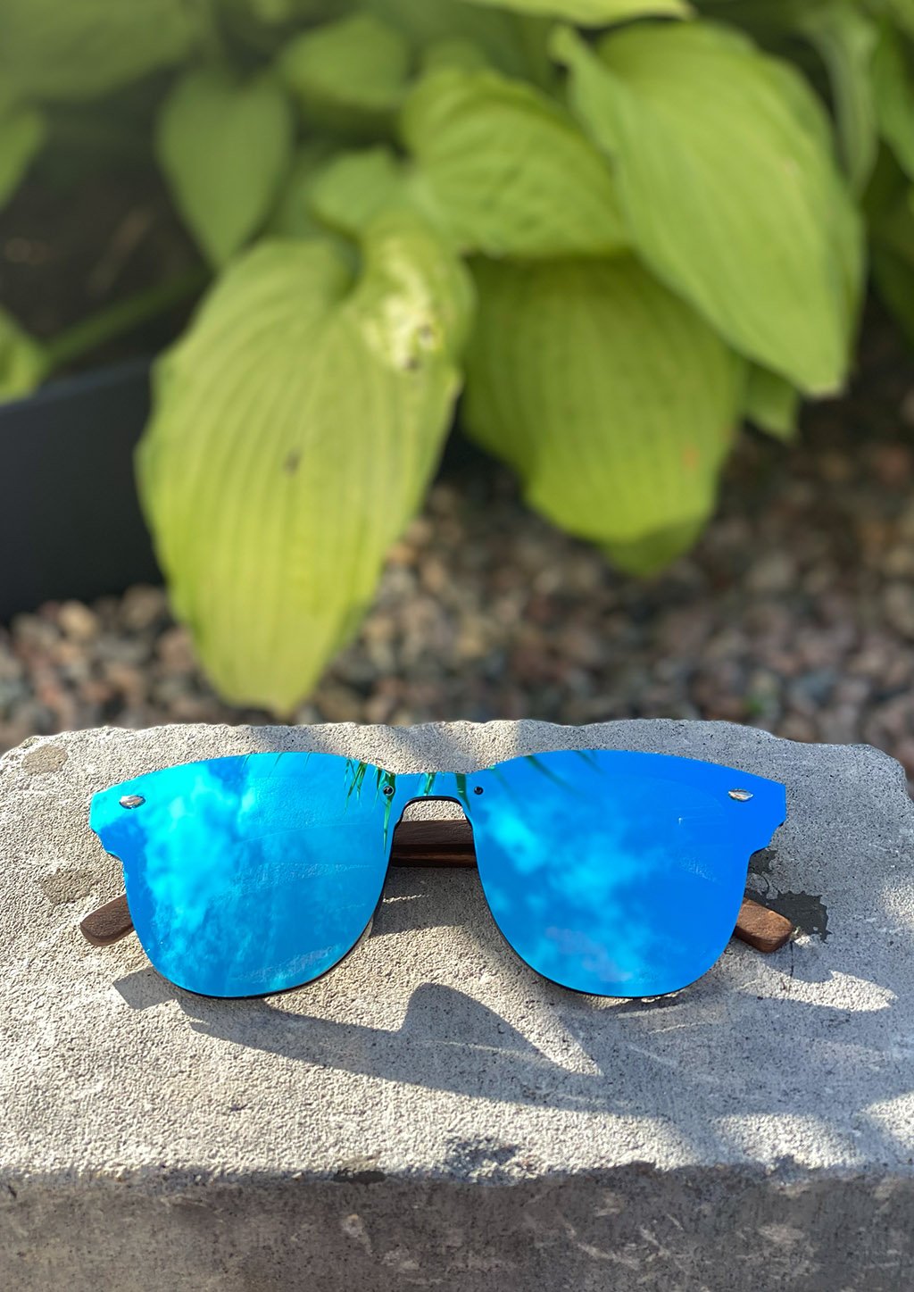 Lunettes de soleil à monture bleue et verres bleus, branches en bois.