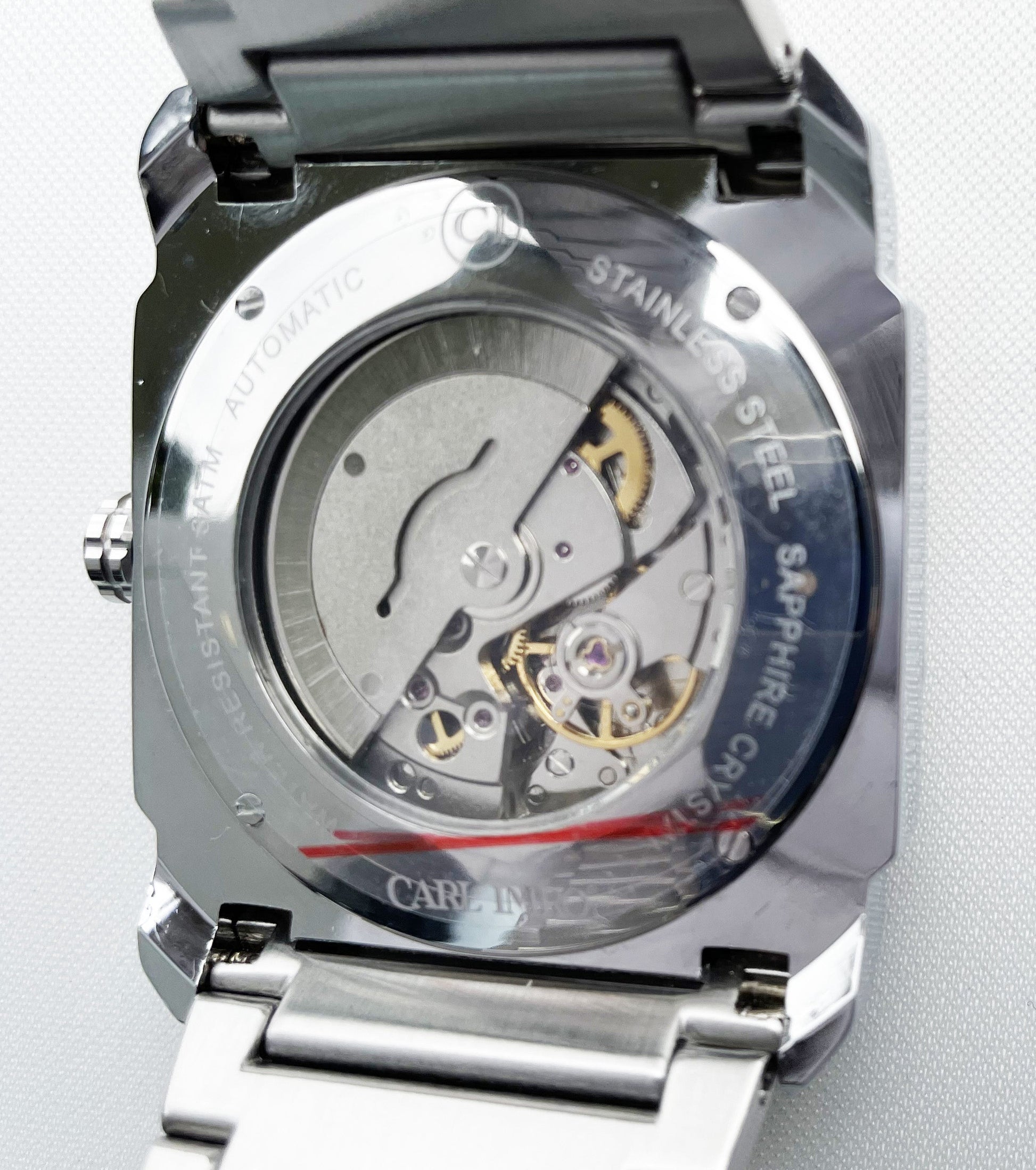 Montre-bracelet argentée, fond transparent montrant le mouvement