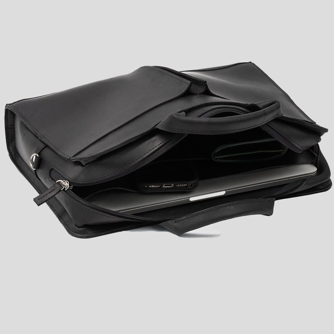 Sac ordinateur en cuir noir ouvert, compartiment rembourré et poches internes