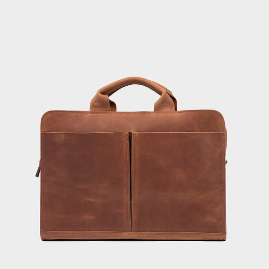 Sac d’ordinateur en cuir cognac à anses, fermeture zippée, intérieur compartimenté.