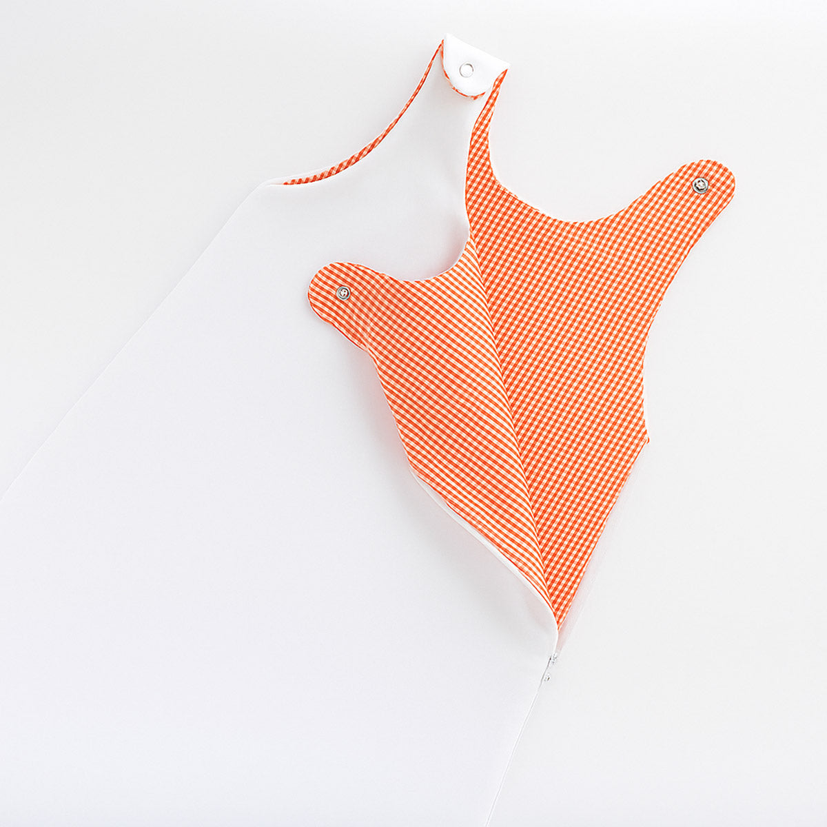 Gigoteuse bébé : intérieur en tissu à carreaux orange, col triangulaire et finitions boutonnées.