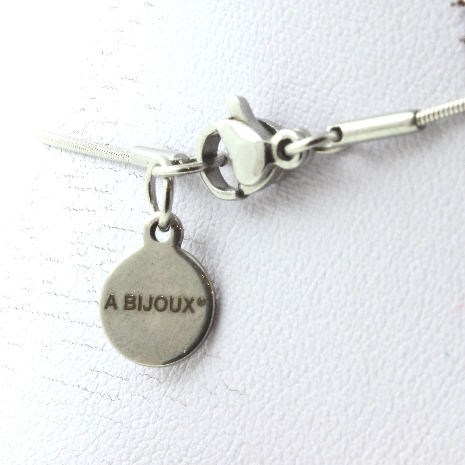 Collier avec fermoir argenté et pendentif rond gravé A BIJOUX.