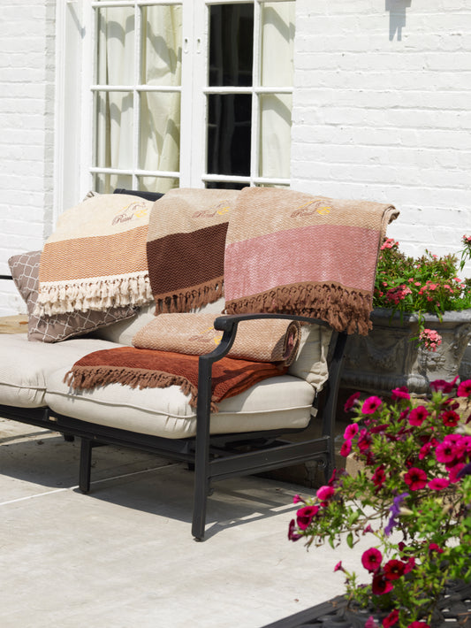 Couverture chevrons beige et rose avec franges, motif « Raul New York » visible