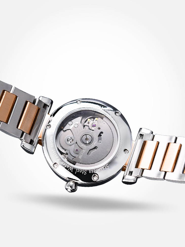 Montre femme Hemys bracelet acier, boîtier rond ouvert montrant le mécanisme automatique.