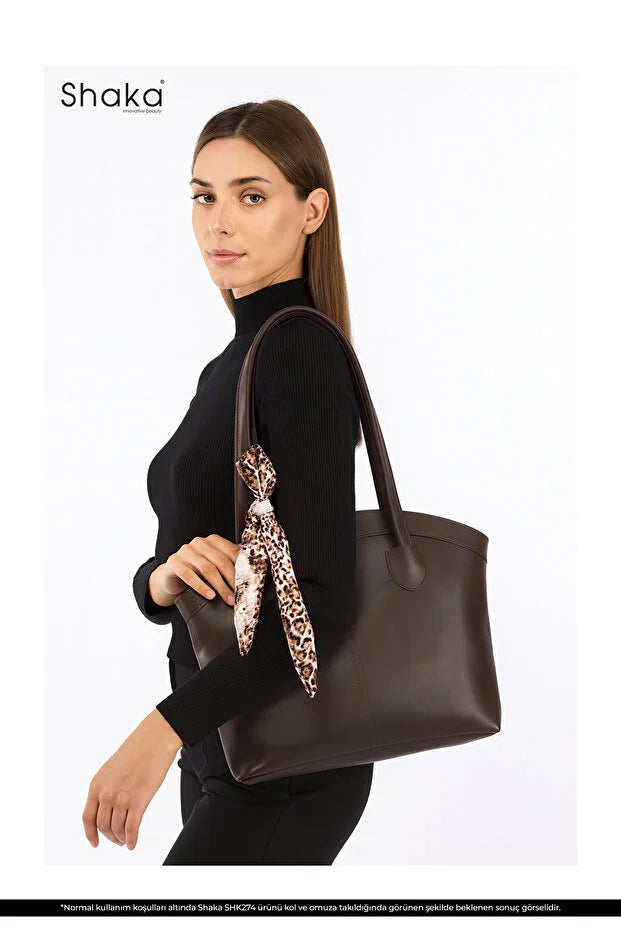 Sac cabas en faux cuir marron, ruban léopard, porté au bras par un mannequin