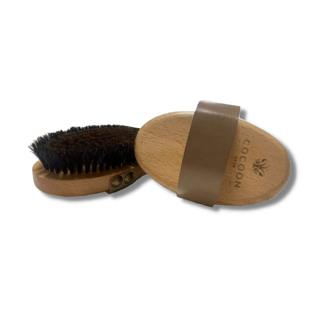 Brosse corporelle sèche COCOON SKIN : manche en bois, picots noirs, sangle marron.