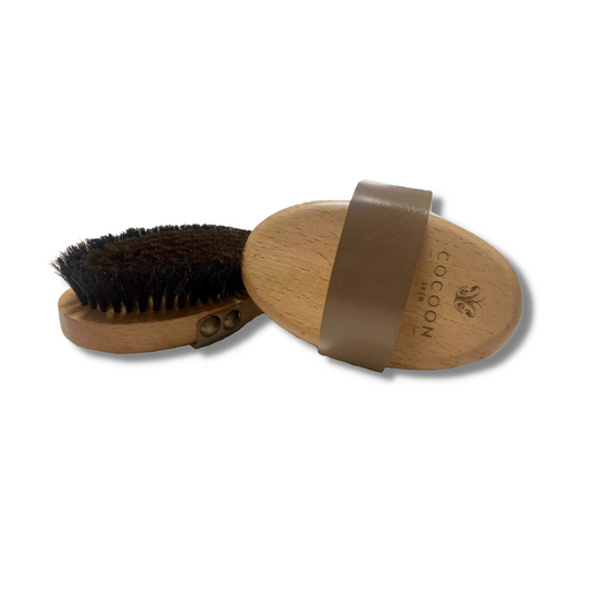 Brosse corporelle sèche COCOON SKIN : manche en bois, picots noirs, sangle marron.