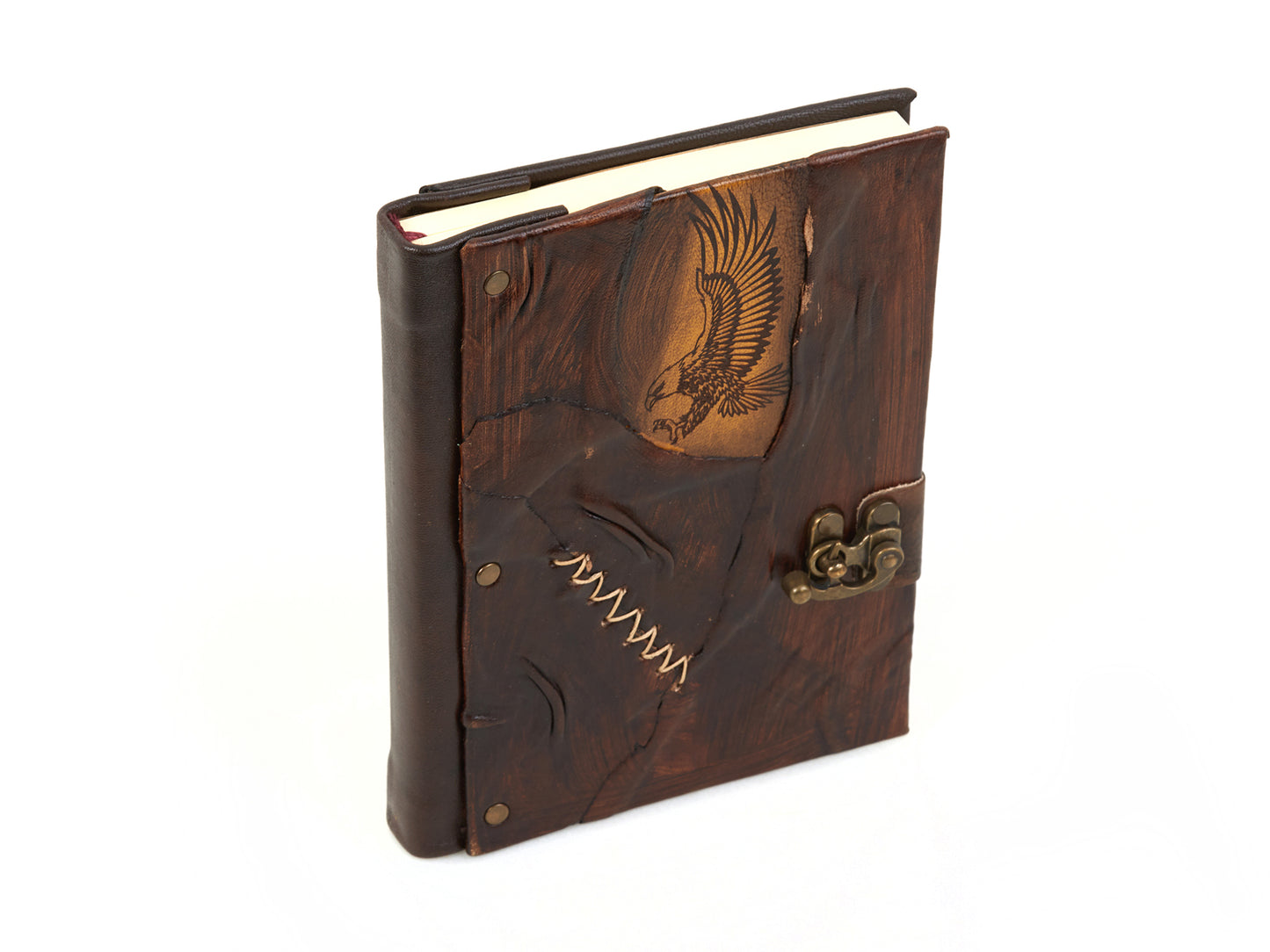 Carnet en cuir marron foncé motif aigle et attache bronze, vue en angle.