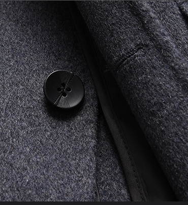 Manteau homme : bouton noir rond sur laine gris chiné, patte et couture visibles.