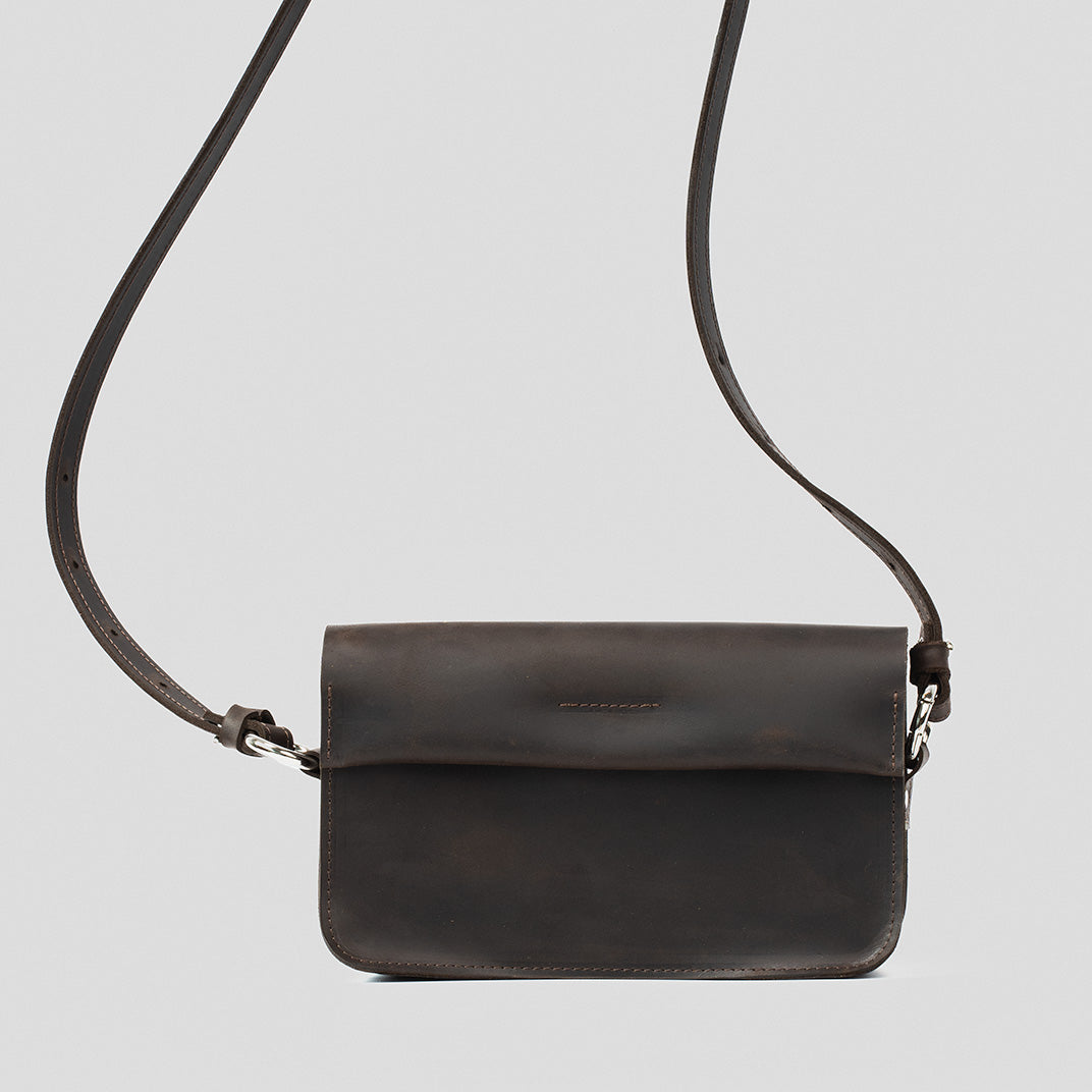 Sac bandoulière en cuir brun foncé, rabat et fermeture à boucle métallique