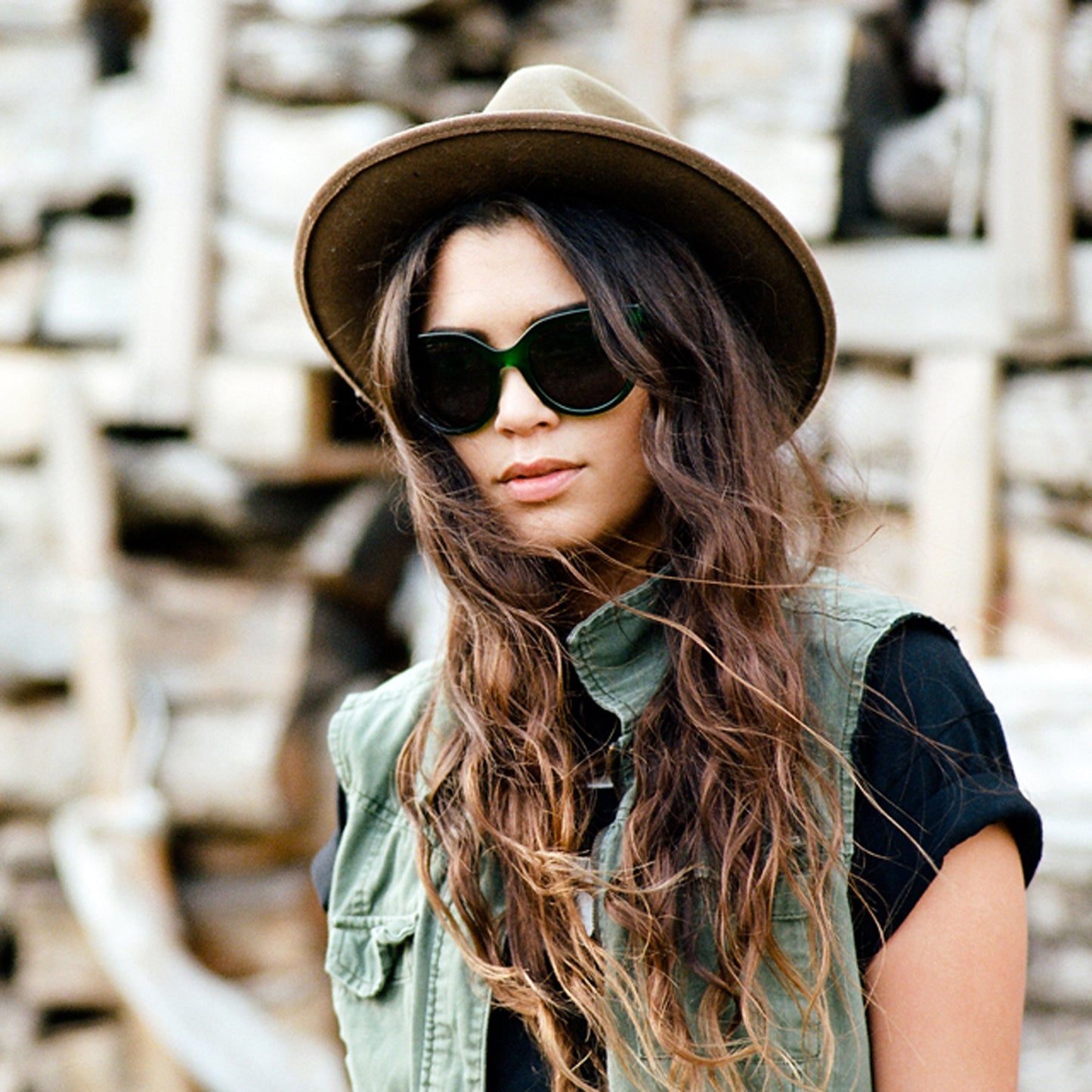 Lunettes de soleil vert émeraude avec étui noir et pochette blanche.