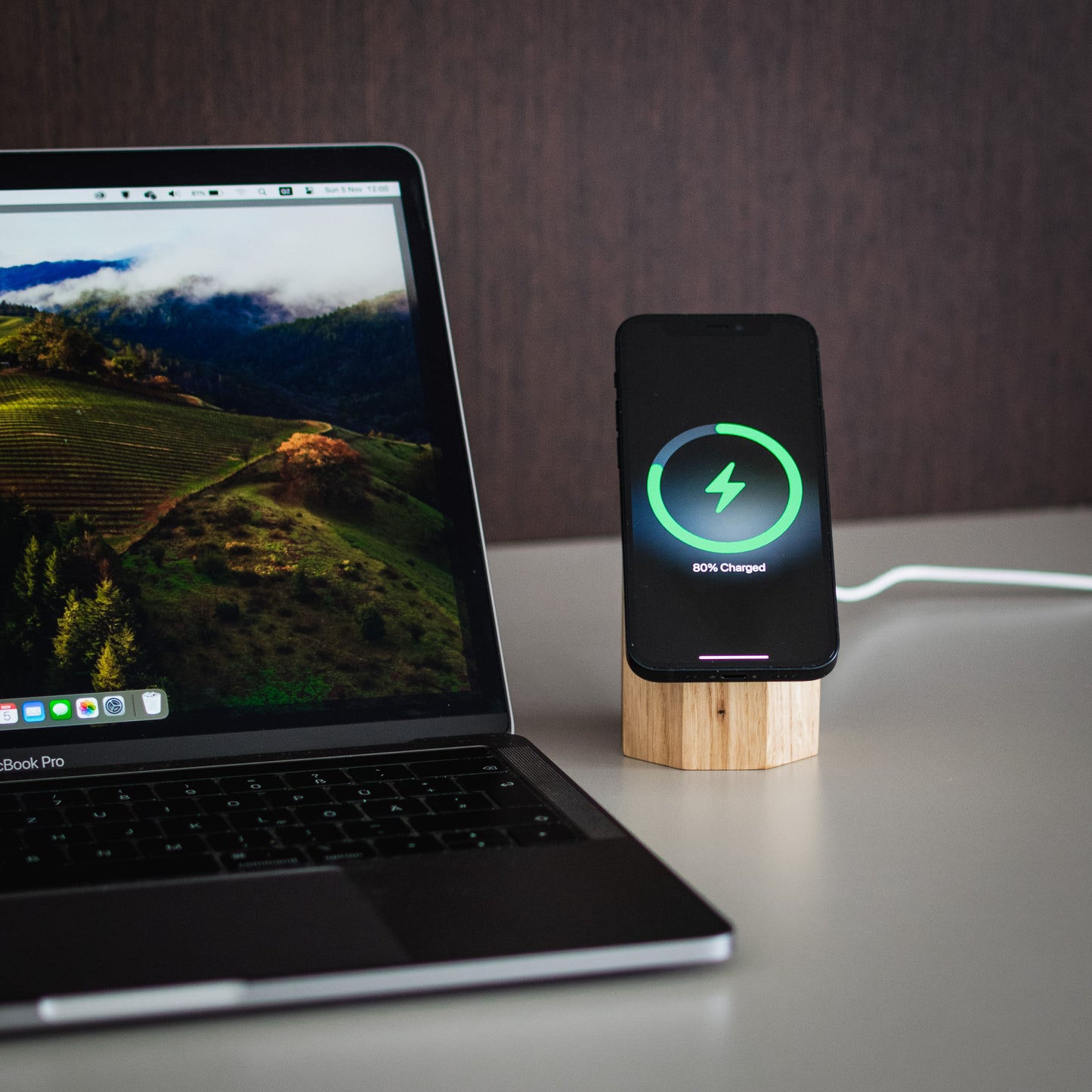 Chargeur sans fil sur socle en bois, voyant vert de recharge sur smartphone