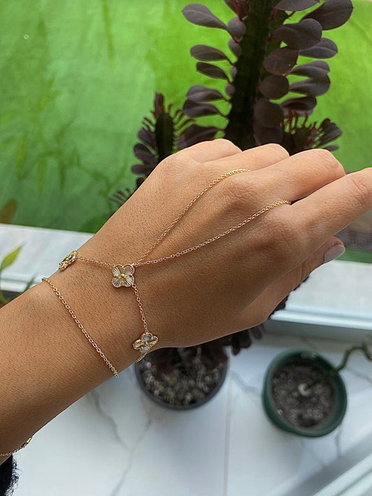 Ensemble de bracelets dorés fins avec trois pendentifs trèfles sur poignet