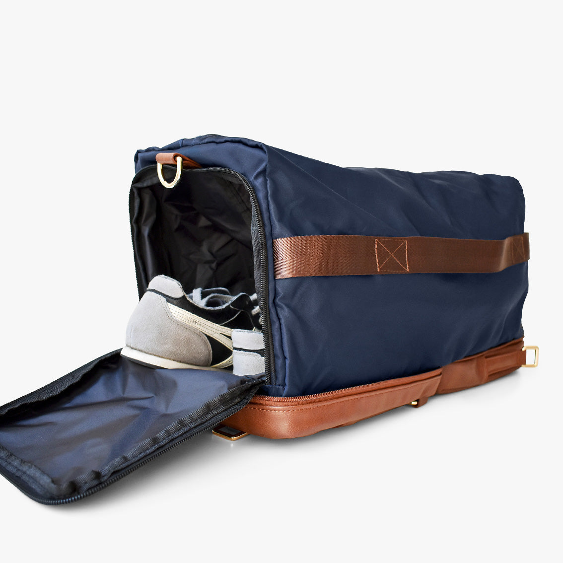 Mini sac bleu avec bandoulière noire, rabat marron et poches zippées.