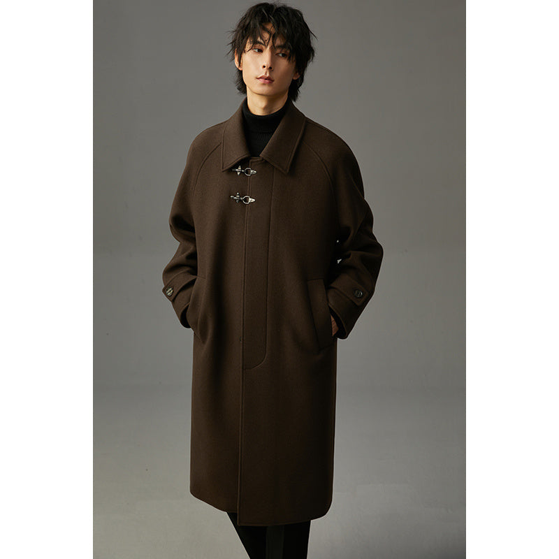 Manteau long en laine café, col à revers, fermeture à boutons duffle et poches latérales.