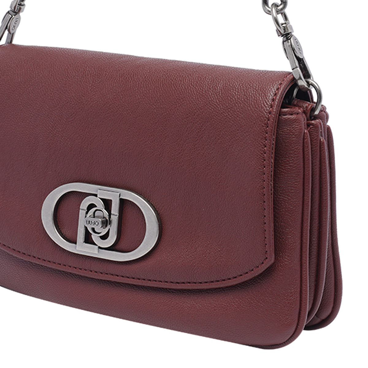 Sac bandoulière bordeaux : rabat et fermoir ovale avec logo, texture grainée
