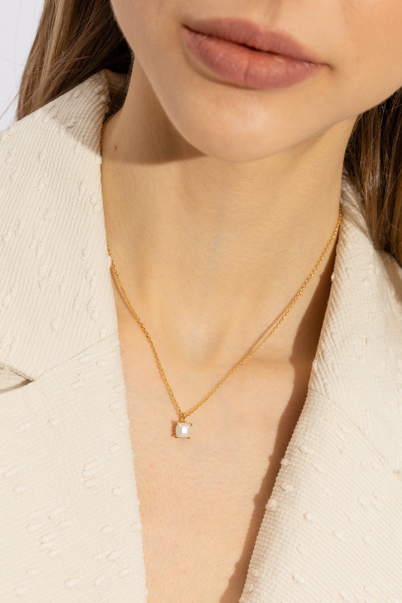 Collier pendentif doré sur le cou, chaîne fine et pendentif à pierre