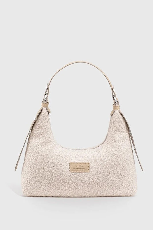 Sac baguette en peluche tressée beige clair, anses et petit logo rectangulaire.