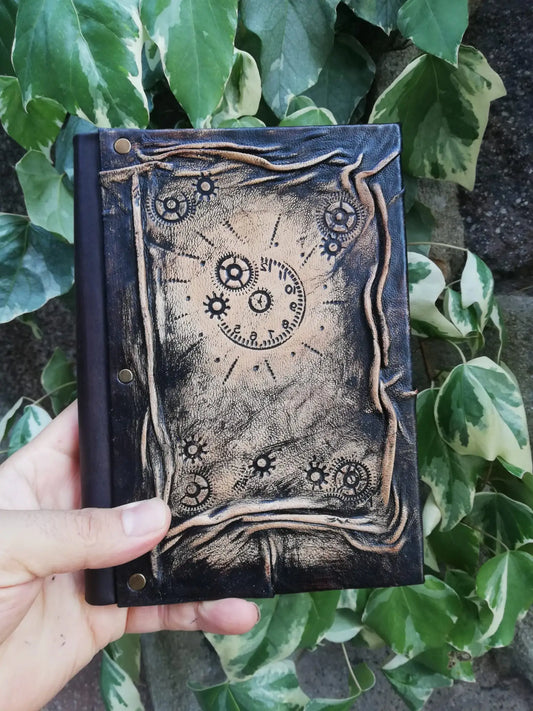 Carnet en cuir foncé avec motif engrenages et horloge, couture et œillets métalliques