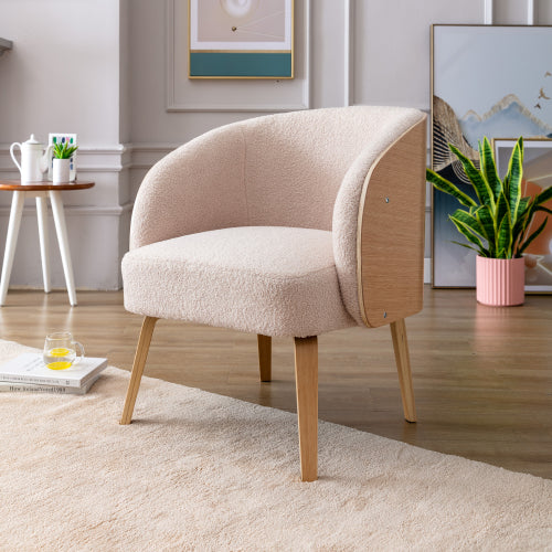 Fauteuil beige en laine d’agneau avec dossier arrondi et pieds en bois.