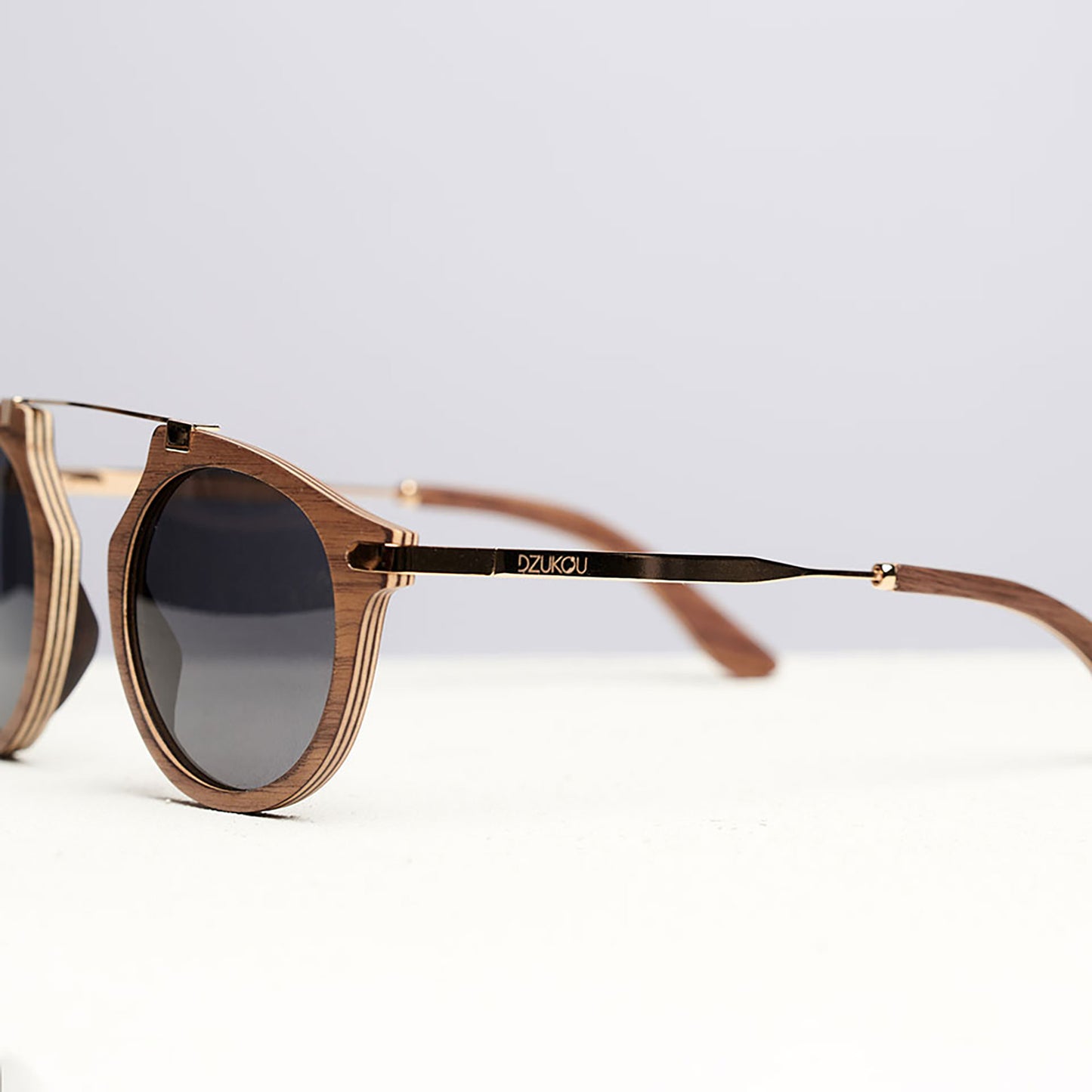 Lunettes de soleil rondes en bois clair, branches longues et verres foncés