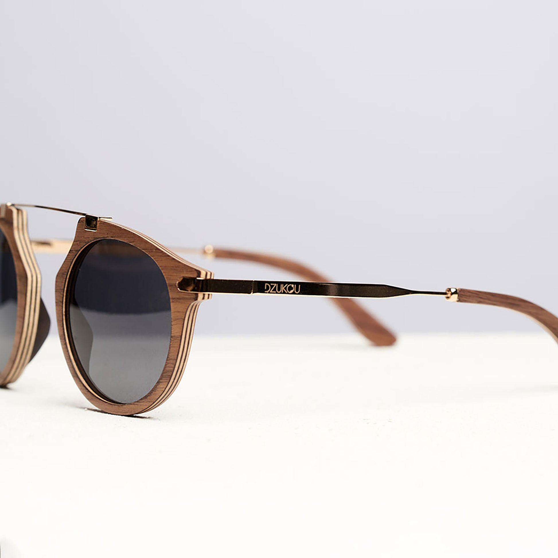 Lunettes de soleil rondes en bois clair, branches longues et verres foncés