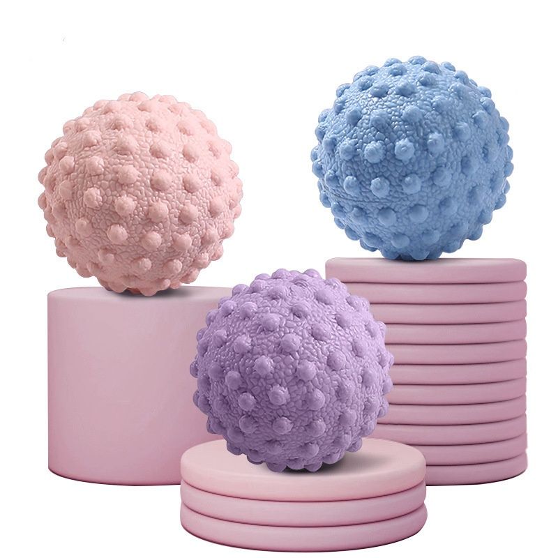 Lot de balles de massage de yoga : rose, bleu et violet, supports empilés.