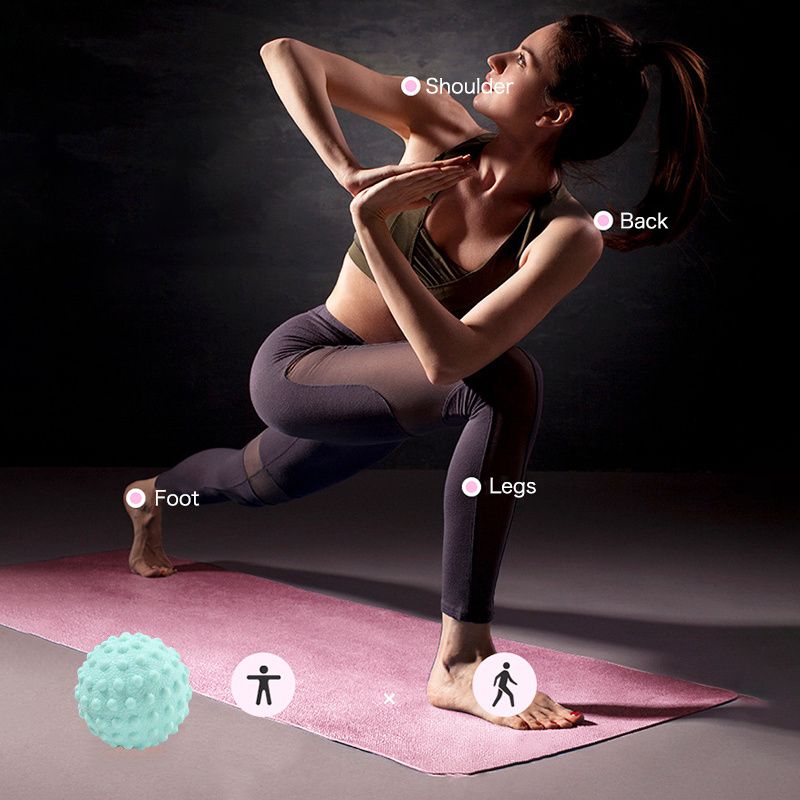 Balle de massage yoga à picots placée au sol avec positions pour le corps