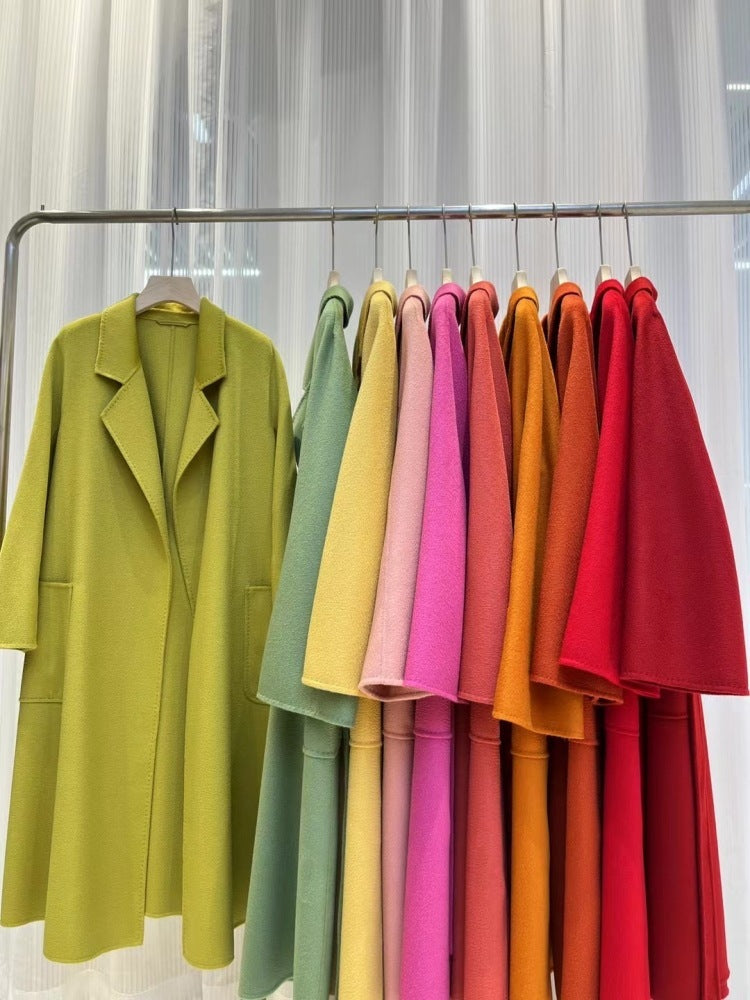 Manteaux longs en laine sur cintres, tons vert, jaune, rose, orange et rouge