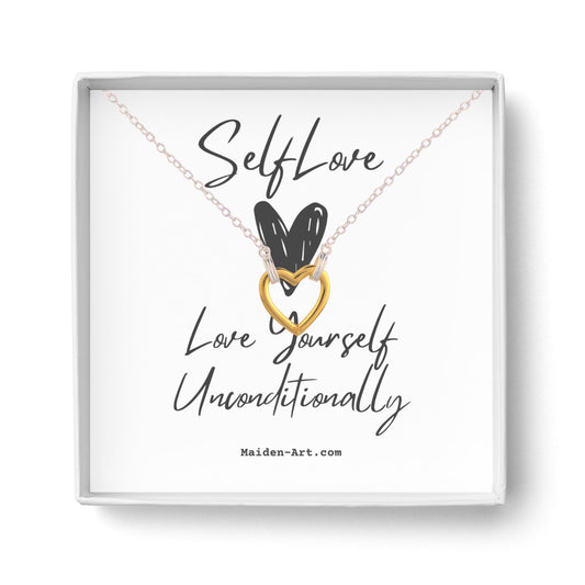 Collier en boîte avec pendentif cœur doré et carte décorée.