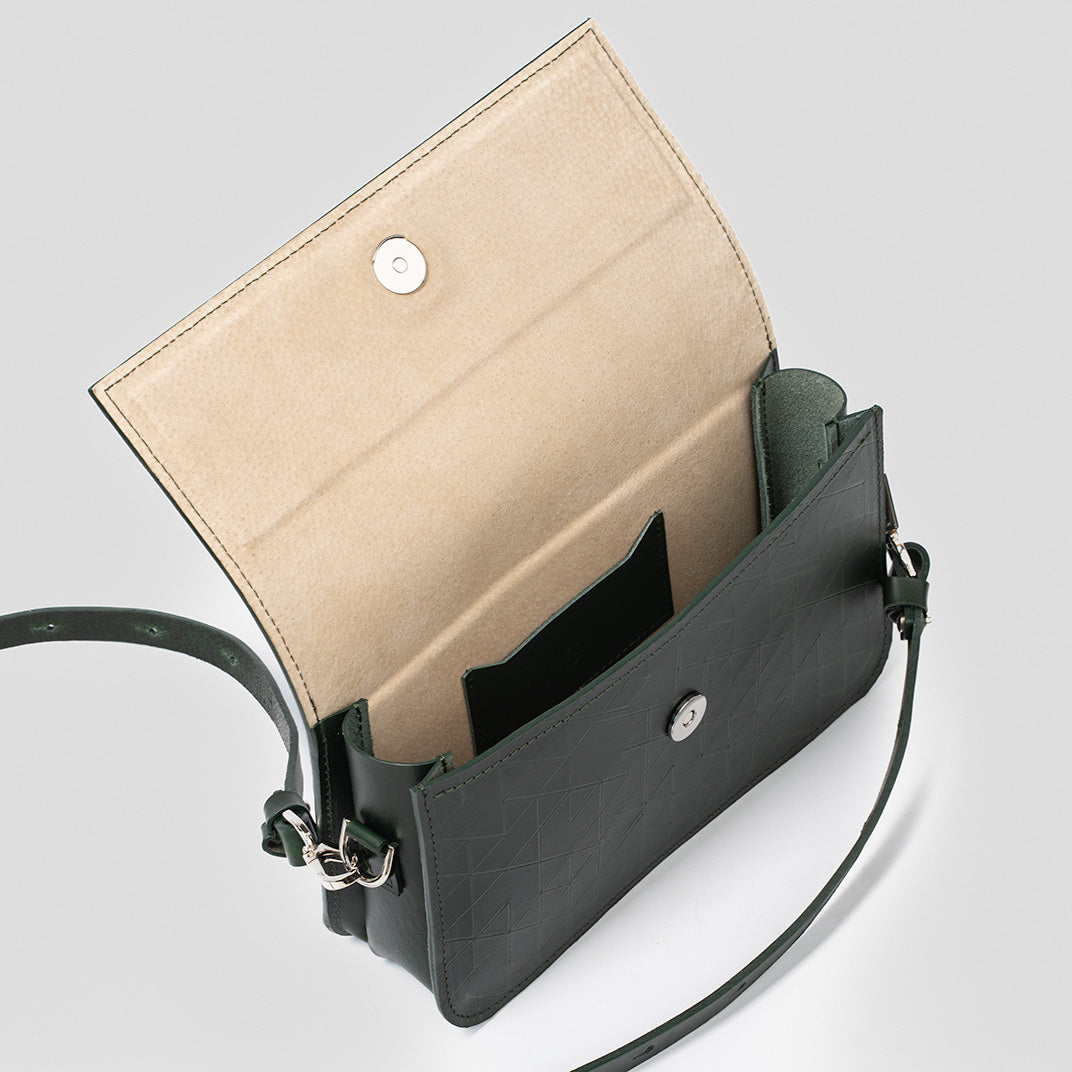 Sac bandoulière cuir vert ouvert, intérieur beige, rabat à bouton-pression et bandoulière.