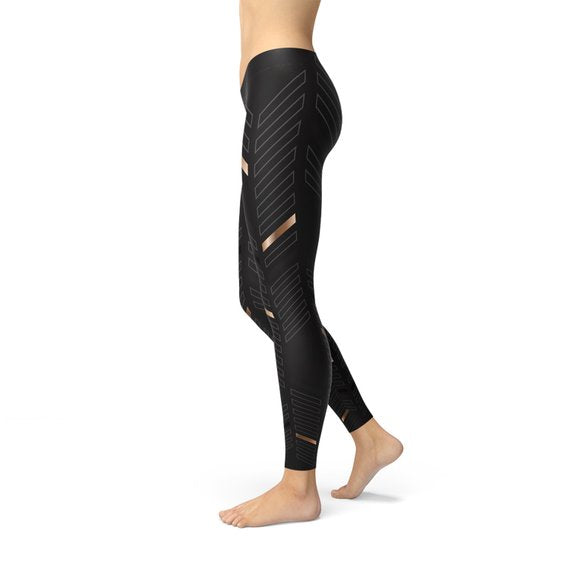 Leggings de sport noirs avec motif rayures géométriques dorées sur la jambe