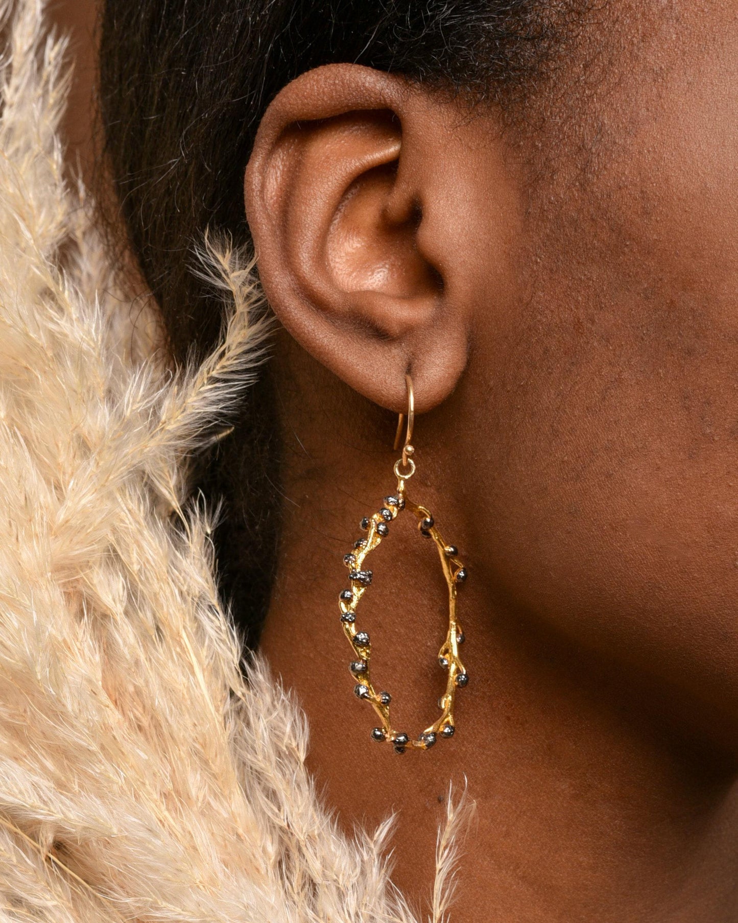 Boucle d’oreille créole dorée, branchage ajouré, petites billes bleues et pampille