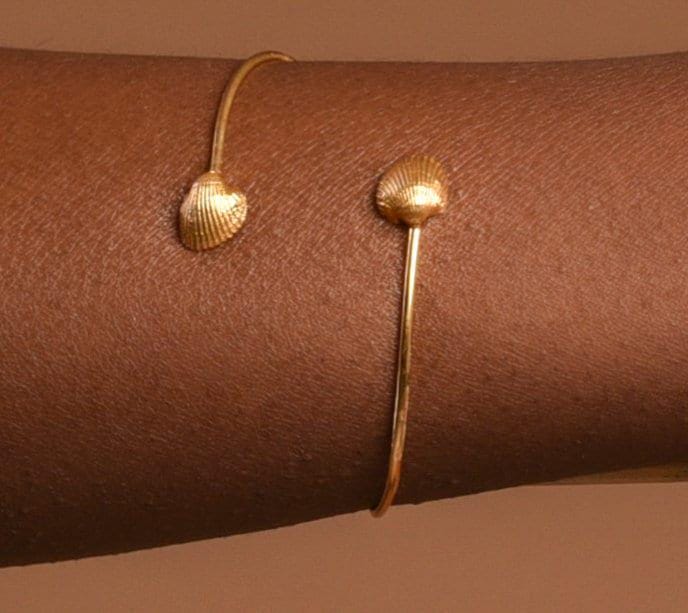 Bracelet manchette doré avec breloques coquillage, vue rapprochée