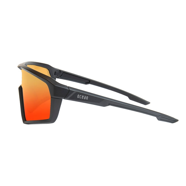 Lunettes de soleil enveloppantes noires, verres orange teintés, vue de côté
